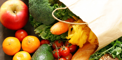 fruits, vegetables, bread, and pasta in a white bag