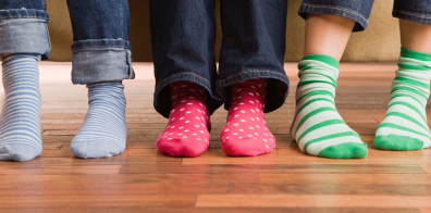 three young people wearing different coloured socks