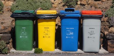 Green, yellow, blue and grey bins in a row 