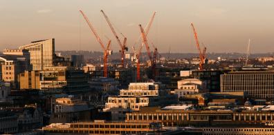 Construction cranes on horizon of city scape