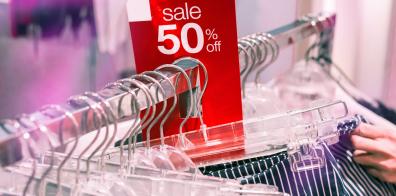 50% off sale sticker on clothing rail
